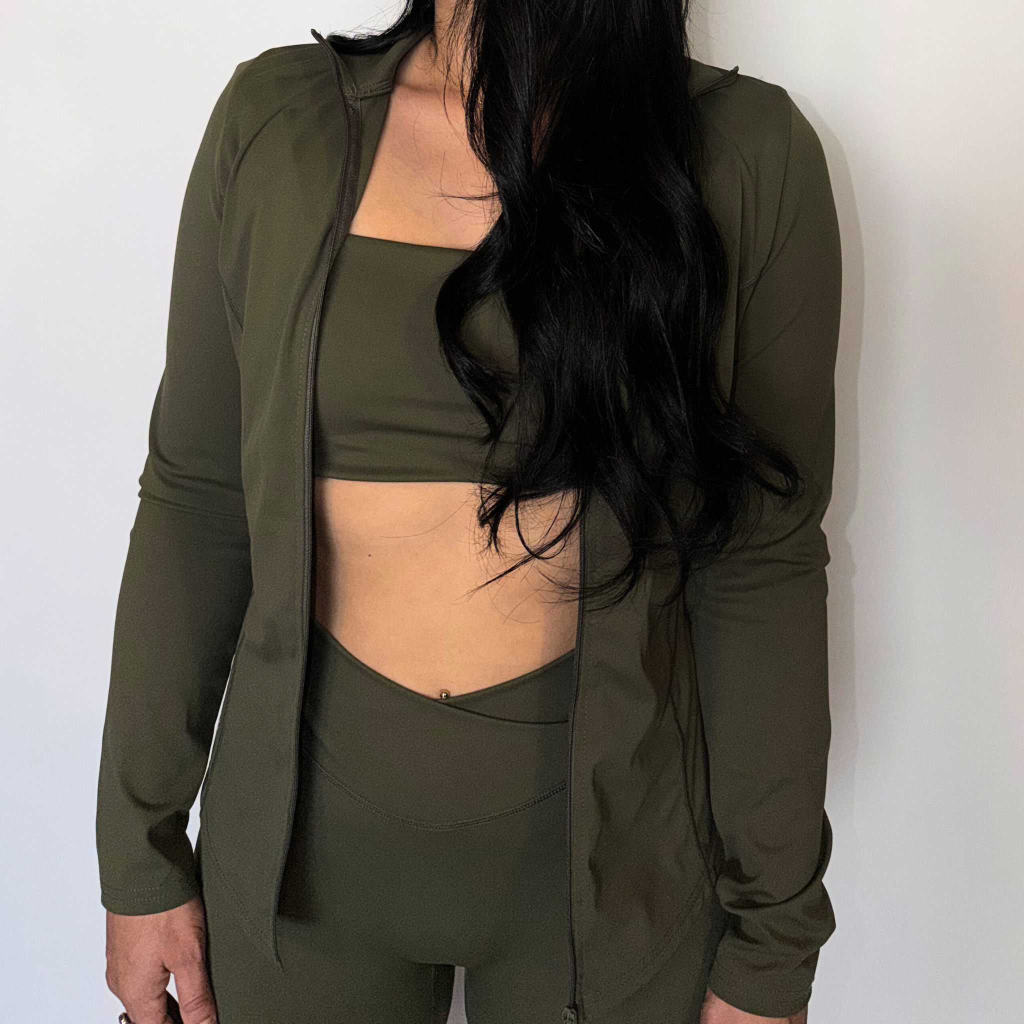 Person wearing an olive green athletic outfit against a white background