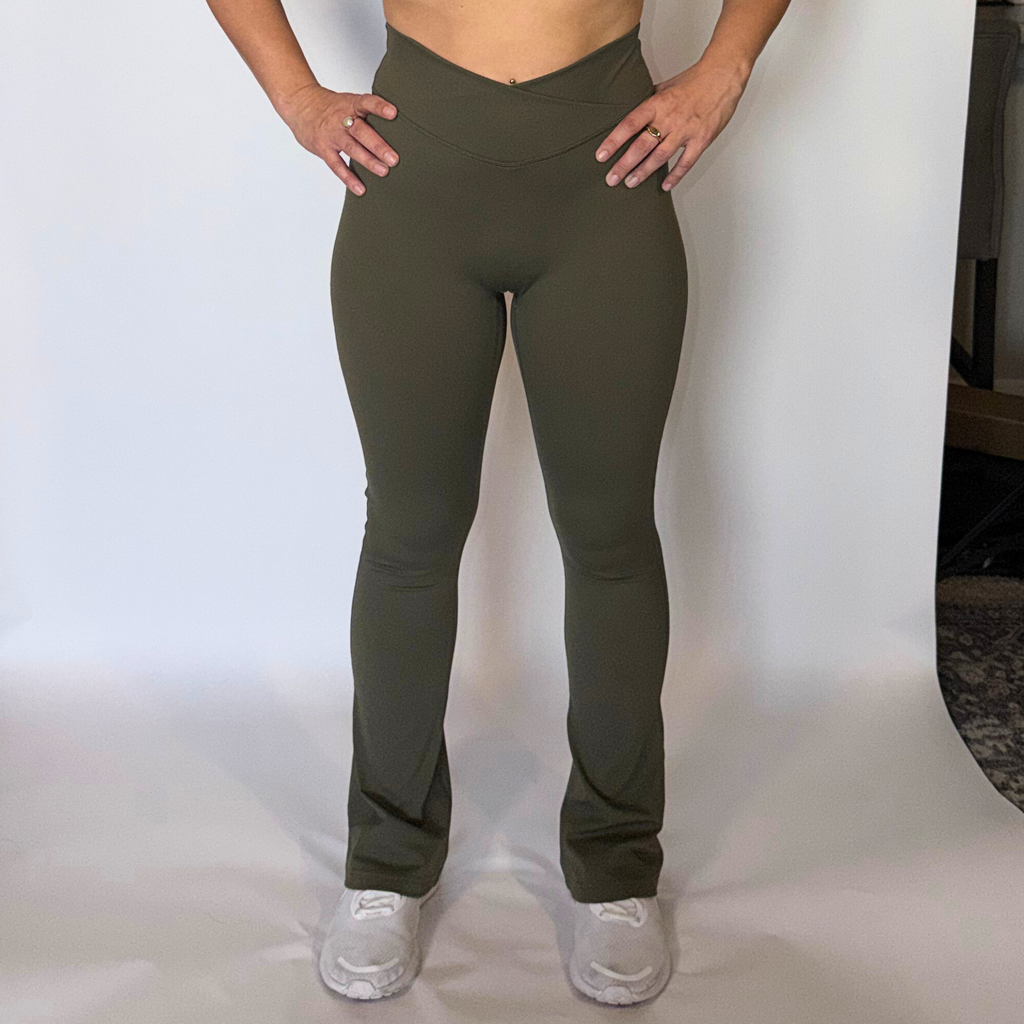 Person wearing olive green leggings on a white background